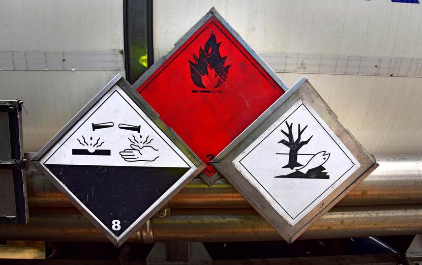 Drie waarschuwingsborden over gevaarlijke stoffen.